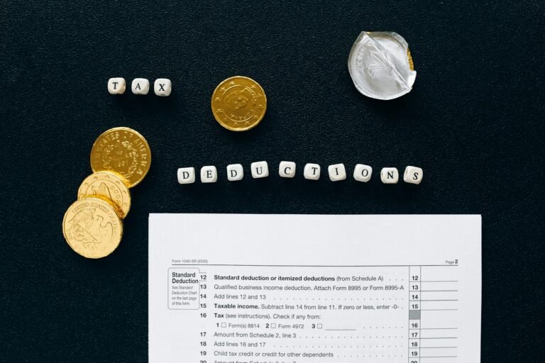 Image of tax deductions concept with coins and tax form on black background.